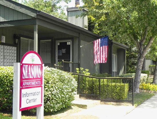 Seasons-Apartments-Shreveport front office with sign and flag