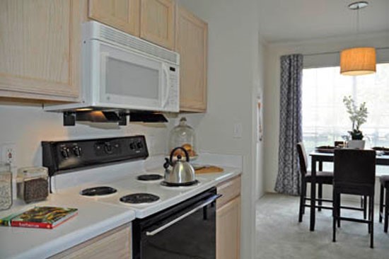 Riverwalk light wood cabinets in model kitchen looking into dining room area