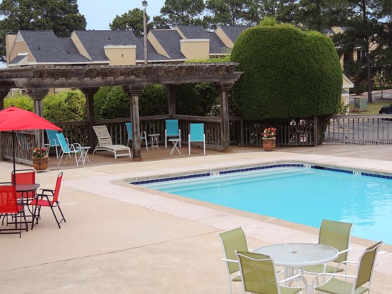 Chimney Hill Apartments Rectangle Pool with Blue, Red, and Green Poolside Lounge Chairs and Tables