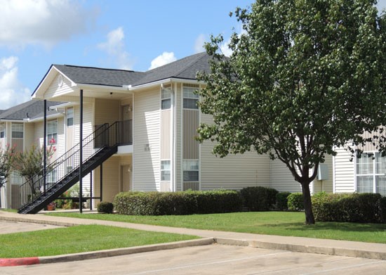 Fox Creek white apartment buildings view from parking lot with sidewalk