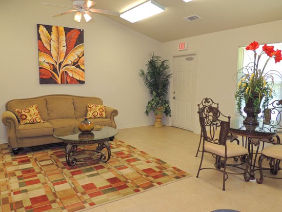 King Oaks Apartments interior of clubroom, inside living area with couch and exit door