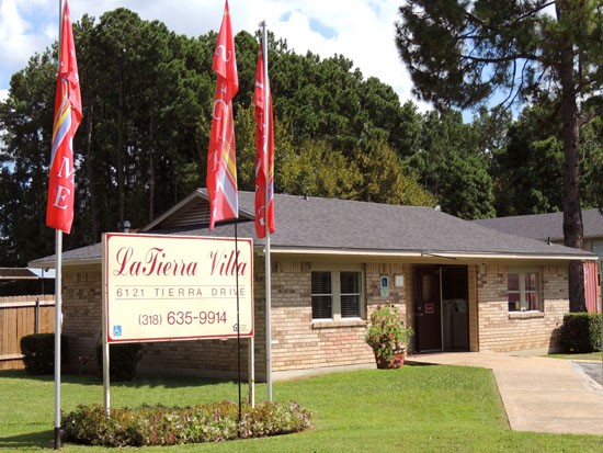 La Tierra beautiful red front sign with three red flags, front office buildings right next to it