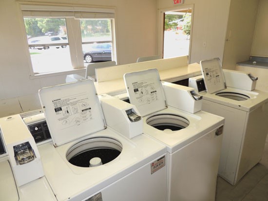 La Tierra Apartments laundry facility with washers and dryers, pay with quarters