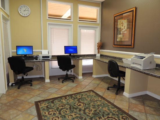 Riverbend Apartments residence work area with desk and computers, printer