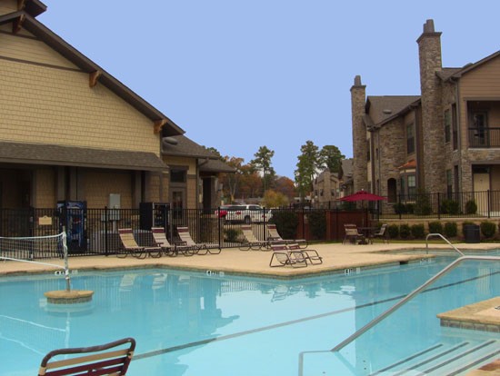 Springridge Apartments big open pool, with volleyball next, backside of clubhouse pool side lounge chairs