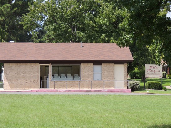 Villa Marquis Apartments backside view of front office building into large open grass area